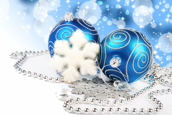 Decoración para el Año nuevo. Hermosas bolas azules con patrones blancos. Copos de nieve blancos y plateados con guirnalda de plata