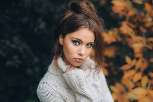 Foto de una hermosa chica en un suéter de otoño