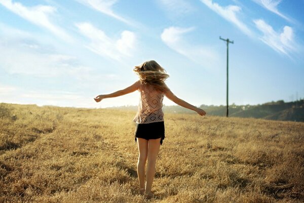 The girl is spinning in the field