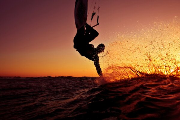 Surfer auf der Welle bei Sonnenuntergang