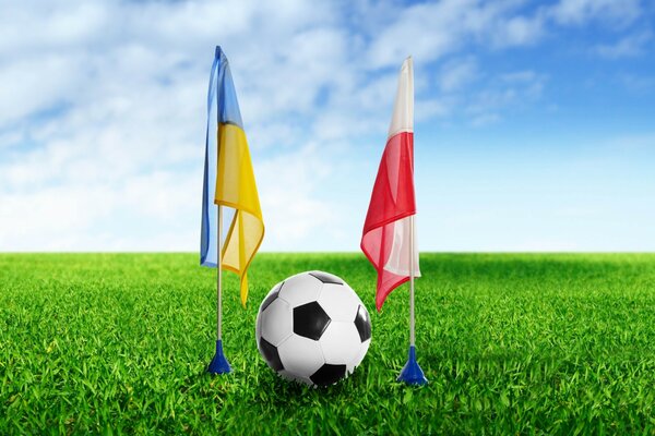 Soccer ball between the flags of Ukraine and Poland