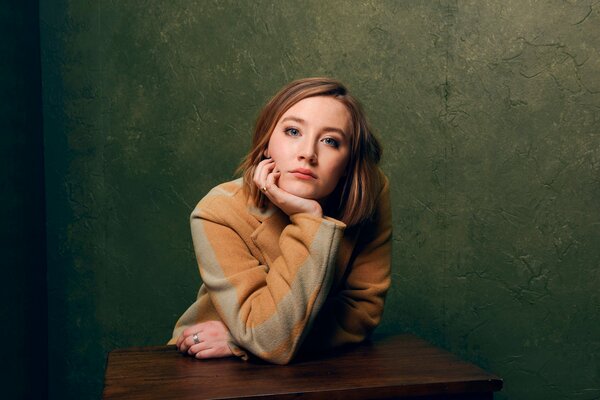 Saoirse Ronan seduto al tavolo