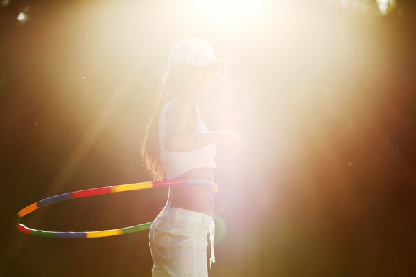 A girl with a hoop in the sunlight