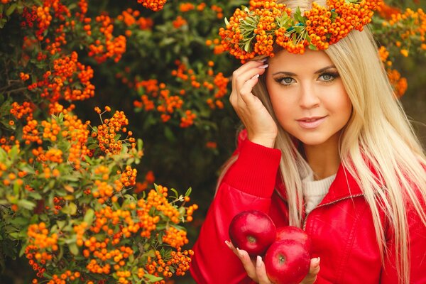 A girl with a wreath on her head and apples