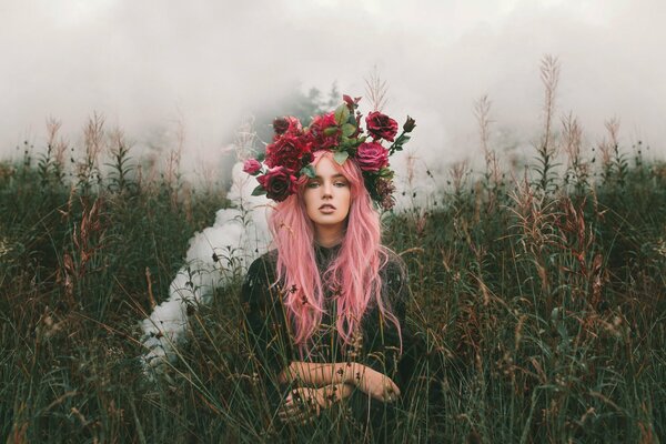 Fille aux cheveux roses et une Couronne de fleurs colorées dans le champ