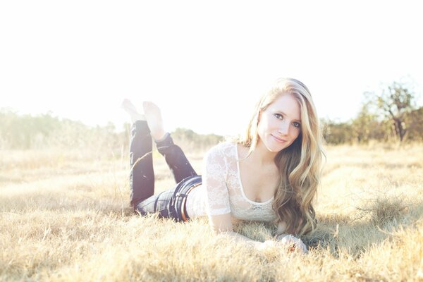 The girl is lying on the grass in a bright, tiny light, a well-known rock