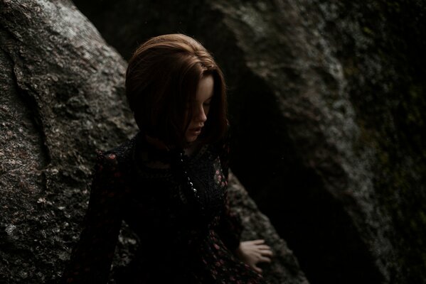 A girl resting her hands on a big stone