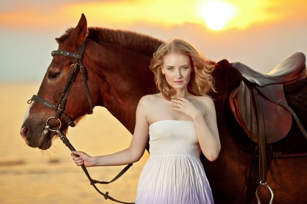 A young girl with a horse on the shore