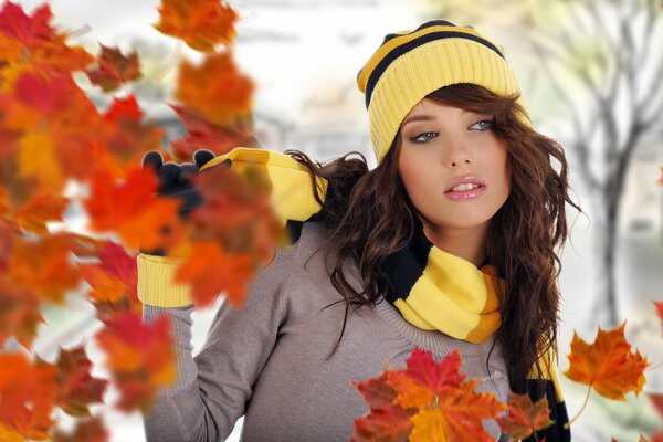 A girl among the flying leaves of trees