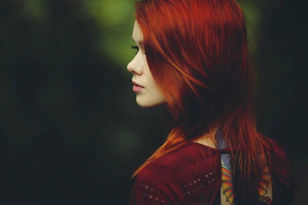 A red-haired girl looks into the distance