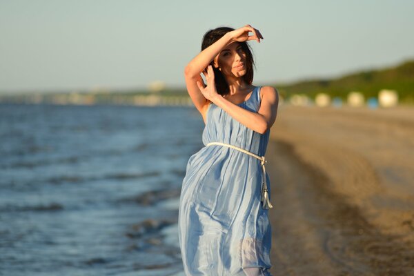 Mädchen auf dem Hintergrund des Strandes unter der Sonne