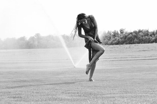 The girl frolics under the spray of water