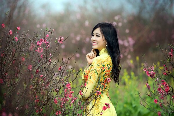 Chica asiática en un Jardín floreciente