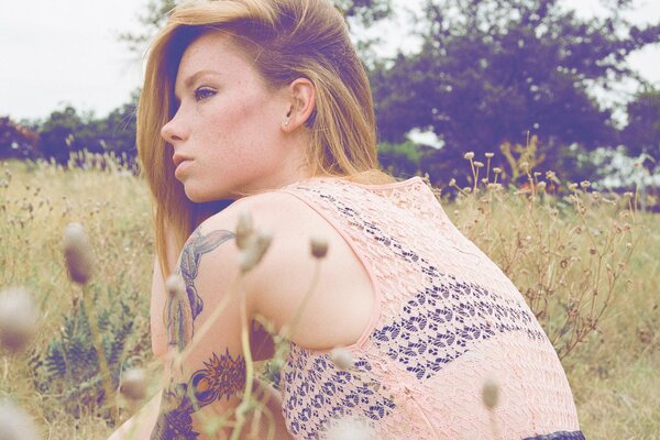 Hetty Watson is sitting on the grass in a field