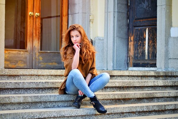 Redhead ragazza si siede sui gradini