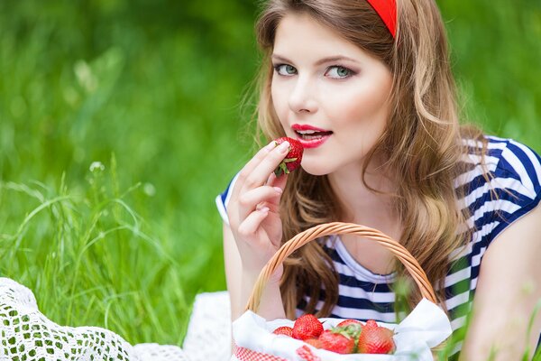 Blonde girl eating strawberries
