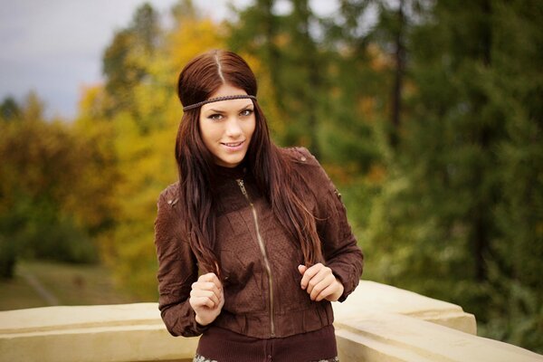 Regina Abakumova poses in a tracksuit against the background of autumn trees