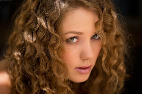 A girl with a beautiful look and curls on her hair