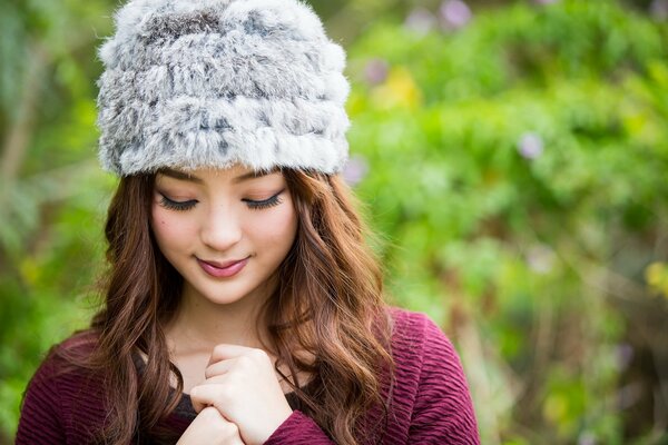 Ragazza asiatica in un cappello nel parco