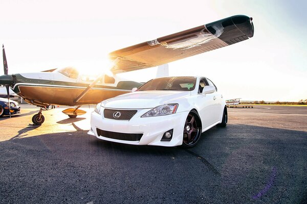 White Lexus under the wing of the plane