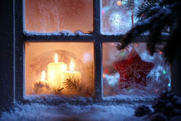 Candles at the Christmas tree outside the window