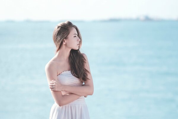 Chica de pie junto al mar azul