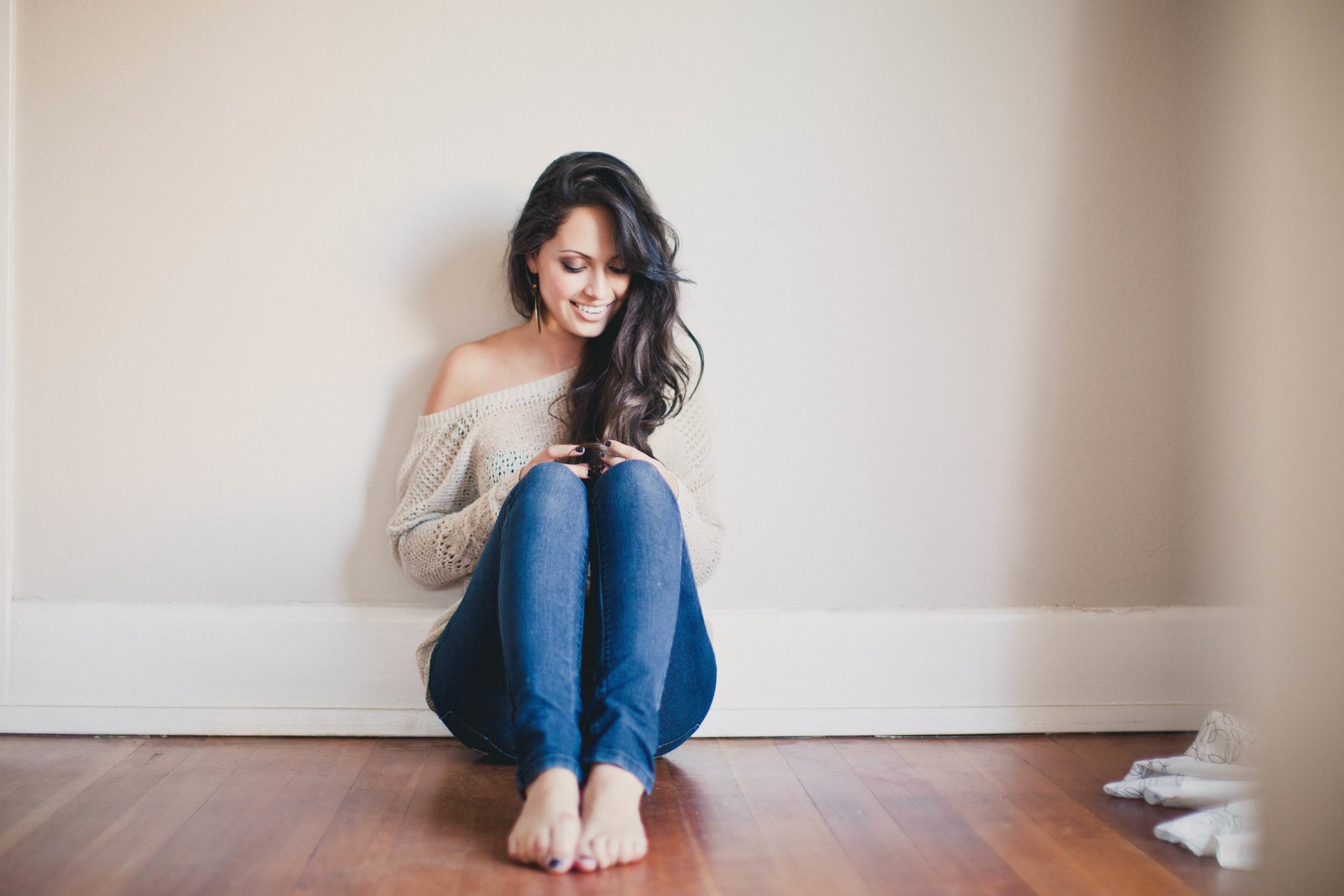 chica morena sonrisa sonriendo rizos sentada pose jeans