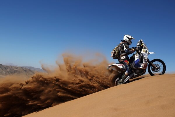 Rennmotorrad mit Rennfahrer in der Wüste von Dakar