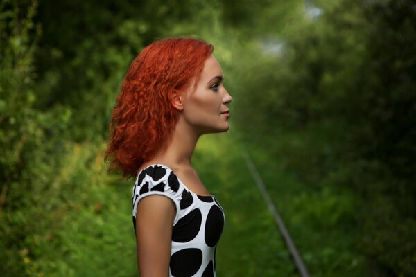 Portrait of a girl with red hair on a green background