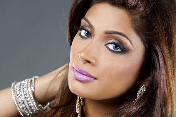 A beautiful girl with bright makeup and a massive bracelet