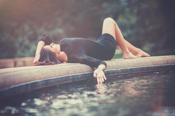 Das Mädchen liegt schön am Brunnen