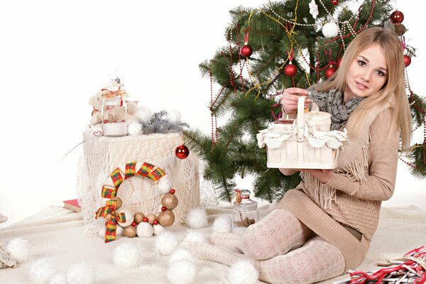 A girl near a Christmas tree with gifts