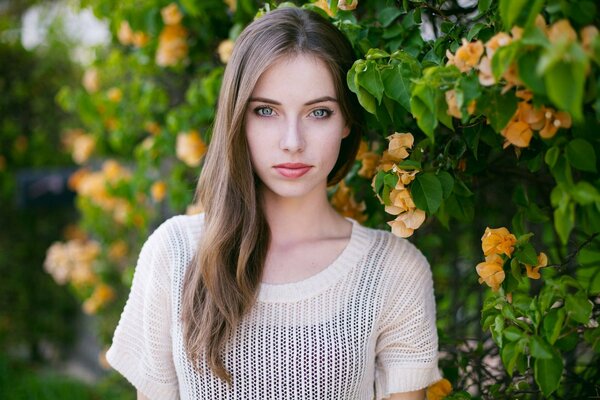Ritratto fotografico della modella Megan Coffey su uno sfondo di fiori