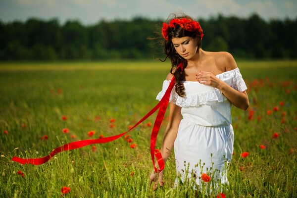 A girl walks in nature on a field with poppies