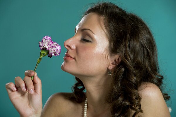 A young girl sniffs a flower