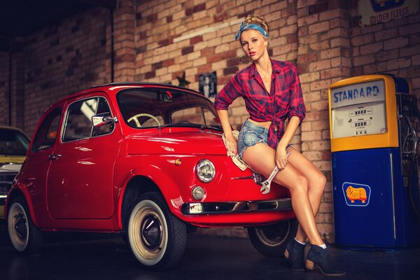 A girl in shorts with a small red car