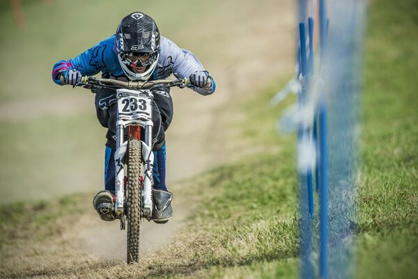 Młody mężczyzna w kasku jedzie po drodze na motocyklu