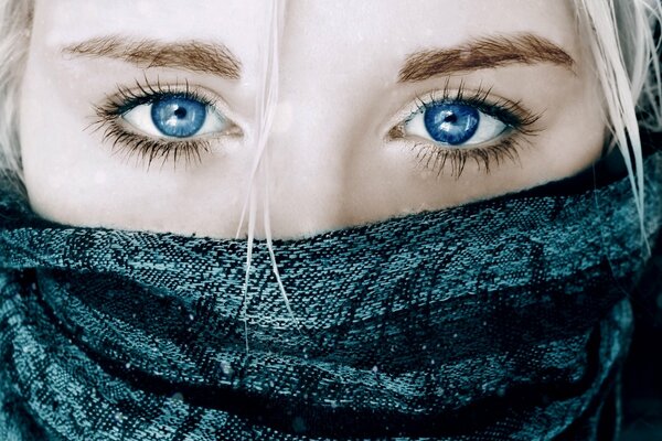 Blonde girl with beautiful blue eyes close up