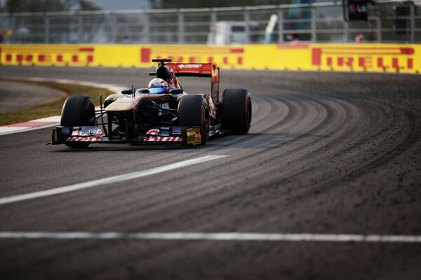 A racing car is driving along the track to the turn