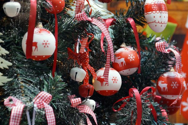 Juguetes coloridos y arcos en el árbol de Navidad