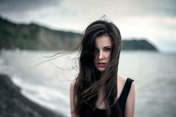 The beautiful Diana Shilovskaya at sea with a striking look, her hair developing in the wind