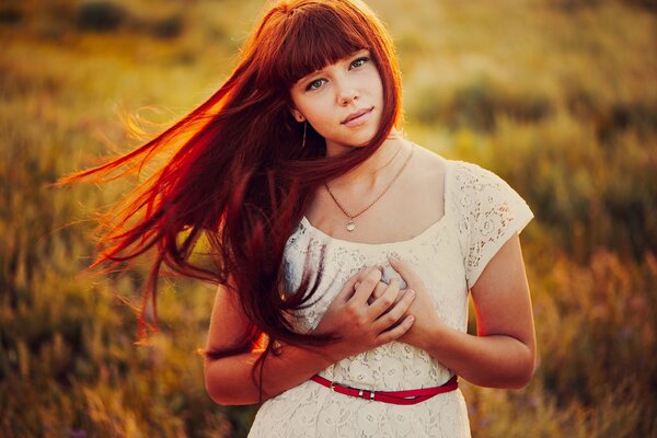 Red - haired girl in the field , the sun