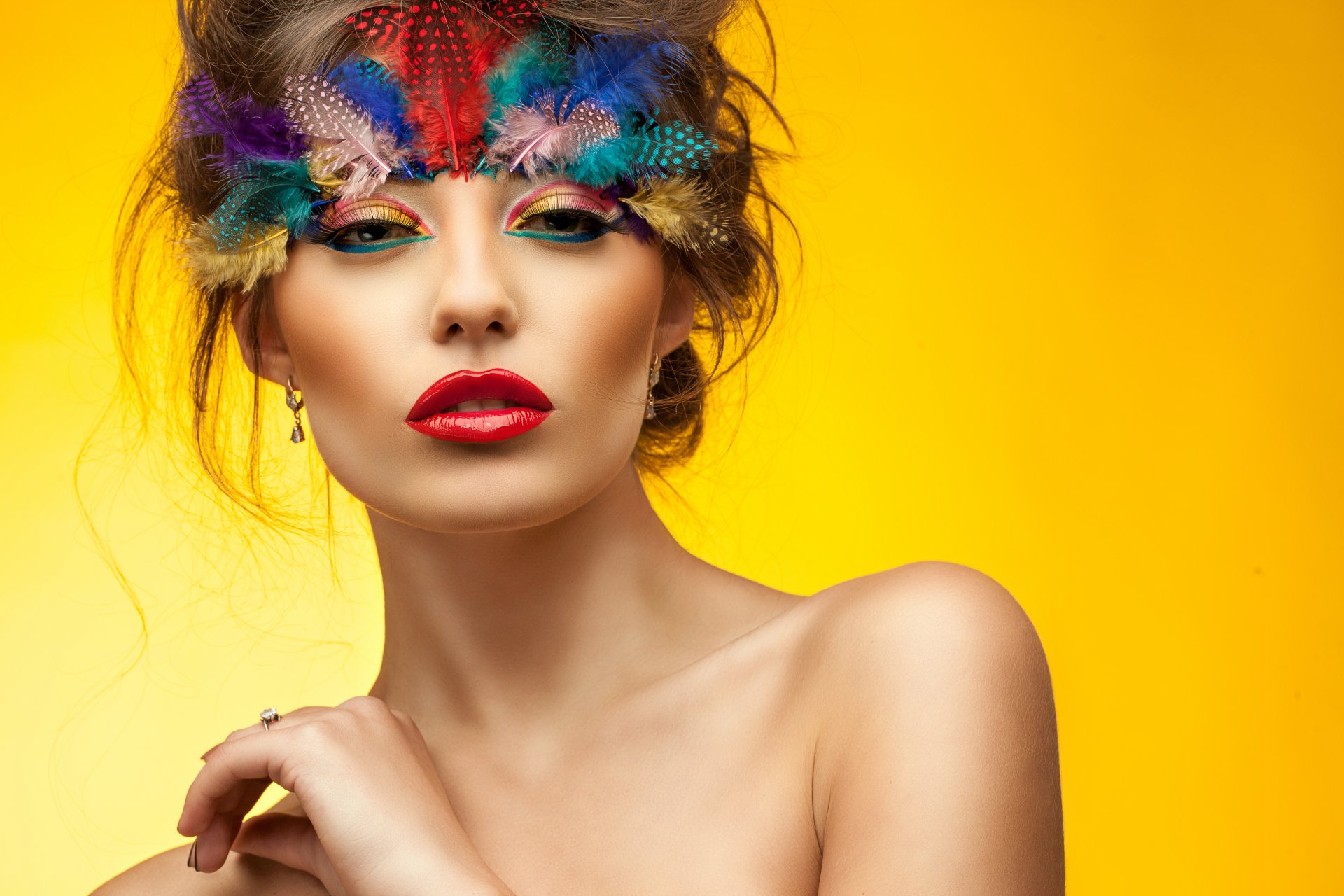 chica maquillaje mirada ojos cara labios rojos plumas brazo cuello hombros fondo amarillo