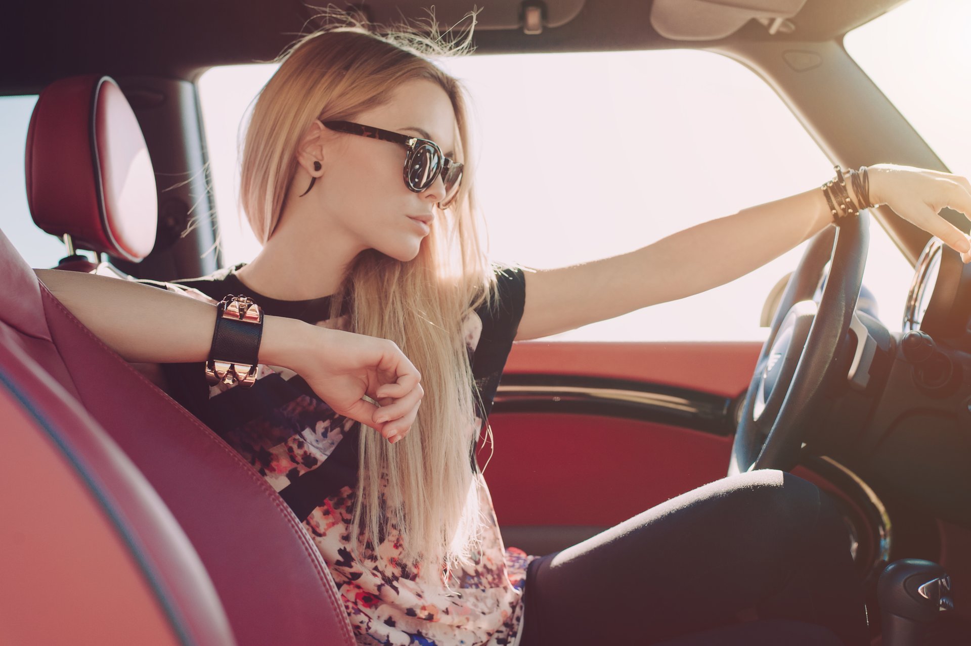 girl blonde section sunglasses sitting machine steering wheel