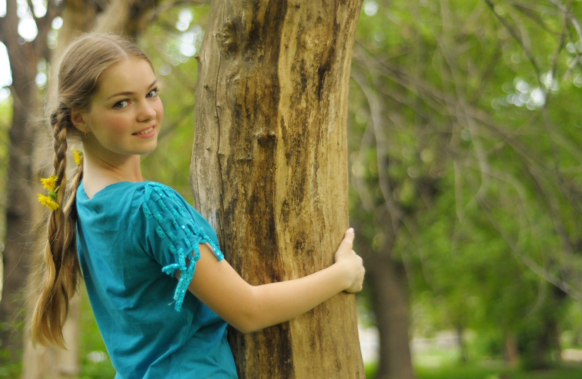 chica ojos grises rubia trenzas dientes de león árbol sonrisa