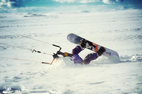 Windsurfer-Athlet manövriert im schnee