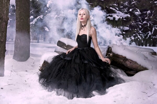 Bride in a black dress in winter in the forest