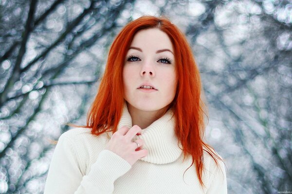 Red-haired girl in the winter forest