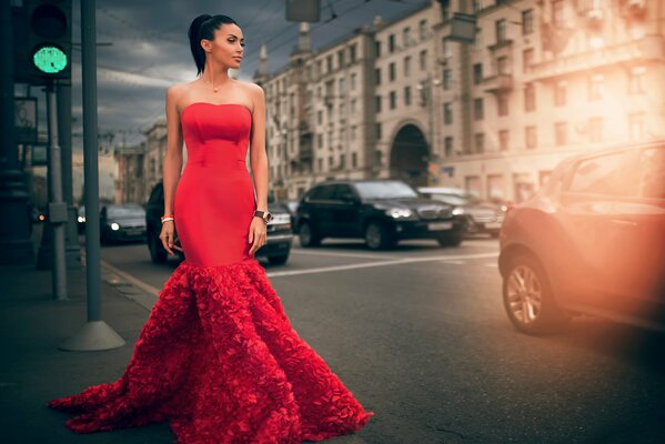 A spectacular woman in a red dress on the street