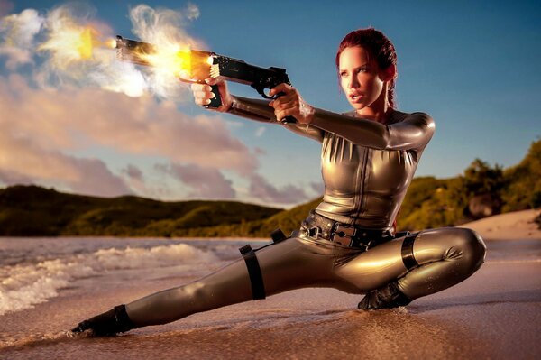 Женщина с пистолетами в руках на фоне морской воды и песка